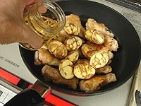鍋の余分な油をふき取り、鶏肉とむき栗を加えます。白ワインを加え、軽く煮立てます。<br />