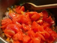 皮を湯むきし、種を取り除いた完熟トマトをダイスカットして鍋に入れ、トマトの水分が出るように炒める。