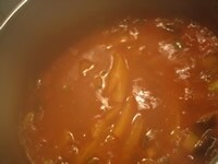 煮込んだら、コンキリエッテ、枝豆、パプリカを入れ、10分程度煮込む。皿に盛り、バジリコの葉を散らし、最後にオリーブオイルをまわしかける。<br />