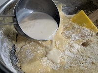 ゴムへらに持ちかえ、ふるっておいた粉類とラム酒入りの豆乳を、2～3回に分けて2に加えてざっくりと混ぜ合わせます。<br />