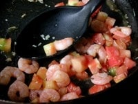フライパンに残りの量のオリーブオイルを熱し、ニンニクを軽く炒めて香りが立ってきたら、むきエビを入れて炒めます。<br />
<br />
全体に油がなじんだら白ワインを加え、トマトも加えてさらに炒めます。エビに火が通ったら塩、こしょうで味を調え、パセリを最後に振って軽く混ぜておきます。