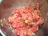 1のねぎの水気をよく絞って、豚ひき肉、ごま油、片栗粉、ナンプラーと混ぜて、手でよく混ぜ合わせます。<br />