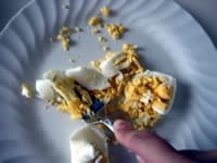 大きめの平らなお皿にゆで卵をのせ、フォークで細かく潰していく。<br />