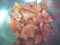にんにくは底を切り落とし、ボウルにたっぷり目に擦り付けます。湯むきしたトマトは、皮と種を落とし、ザク切りにしてボウルに入れ、塩をして混ぜ合わせます。<br />