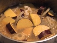 鍋にごま油を熱し、鶏ひき肉を炒めます。お肉に火が通ったら、水気をよく切ったさつまいもとれんこんを加えて、さらに軽く炒めます。全体に油が回ったら、だし汁とみりんを加え、途中アクをとりながら再沸騰するまで強火で煮ます。<br />