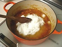 サラシ袋を取り出した鍋に砂糖を加えます。よくかき混ぜて弱火で20分ほど砂糖が完全に溶けるように煮ます。<br />