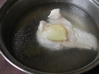 鶏肉は皮を取り除いて、生姜を加えて、水からゆでます。中まで完全に火が通るまでゆでたら、水洗いして余分な脂を落としてキッチンペーパーで水気をよくふき取ります。