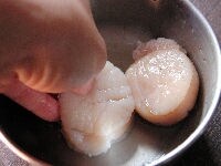 ホタテの貝柱を貝から外し、塩水で洗ったら水気をおさえます。それから日本酒で軽くふり洗いします。（このとき、酒の水分はふきとらずにそのままにしておきます。）