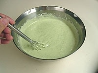 生クリームのボウルに抹茶ゼラチン液を加え混ぜ合わせ、次にメレンゲを加え混ぜ合わせます。<br />