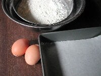卵は室温に置いて常温にします。粉類（薄力粉、ベーキングパウダー、ベーキングソーダ）は合わせて2度ふるっておきます。型の底に合わせてワックスペーパーを敷きます。オーブンは170度に設定し、予め温めておきます。<br />