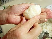 蒸し上がり半つきにした餅を、あずき餡の方は少し小さめに、きな粉と胡麻の方は少し大きめに俵型に作ります。<br />