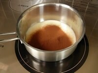 鍋にコンデンスミルクを入れ弱火にかけ、温まってきたらココアパウダーを茶こしでふるって入れ、混ぜ合わせます。 <br />